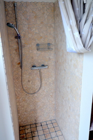 Dusche in der Sauna, die 
sich um die Hausecke 
herum befindet